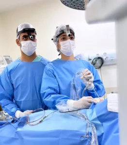 O casal de otorrinos em uma mesa de cirurgia juntos cuidando de um paciente.