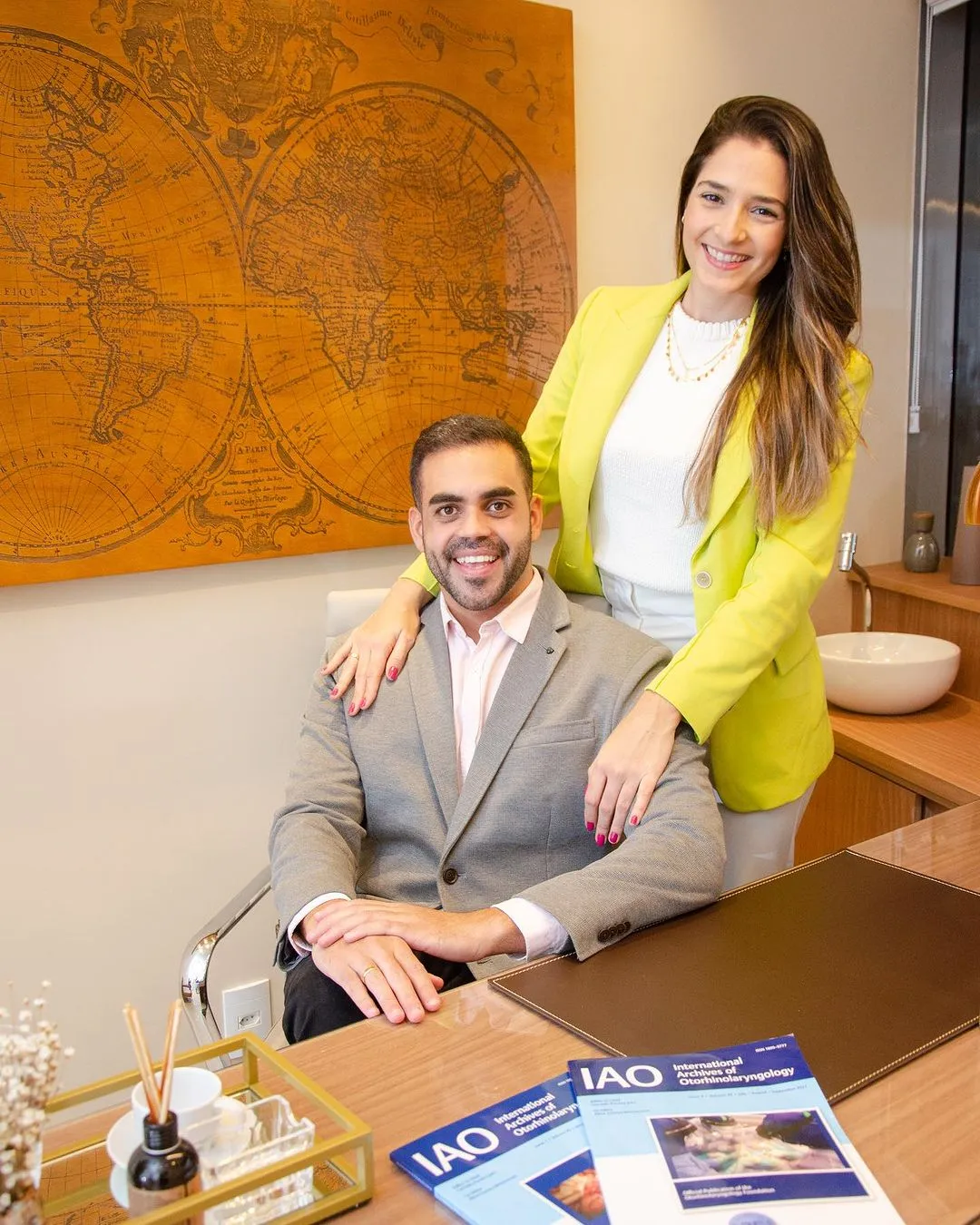 O Dr. Guilherme Menezes sentado e sua esposa a Dra. Isabela Martins ao seu lado no consultório da Sinus Prime a Clínica da Família com tradição e especialidade em otorrinolaringologia