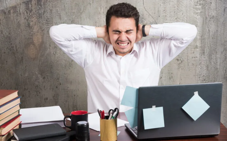 Funcionário de escritório com forte dor no ouvido no trabalho.